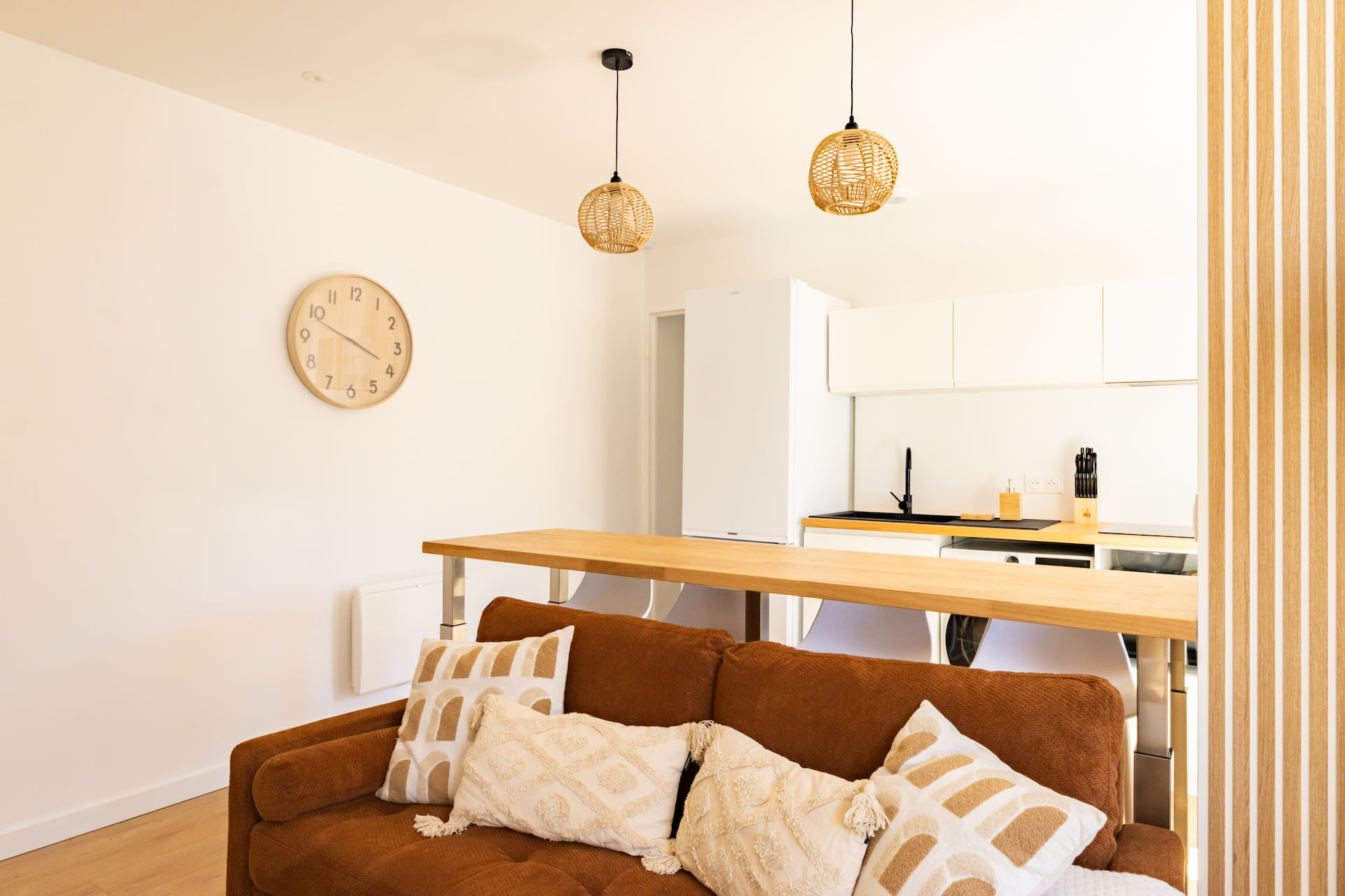 Pièce de vie rénovée d'une colocation à Dax avec salon, espace repas et cuisine ouverte équipée, dans un appartement aménagé clé en main.