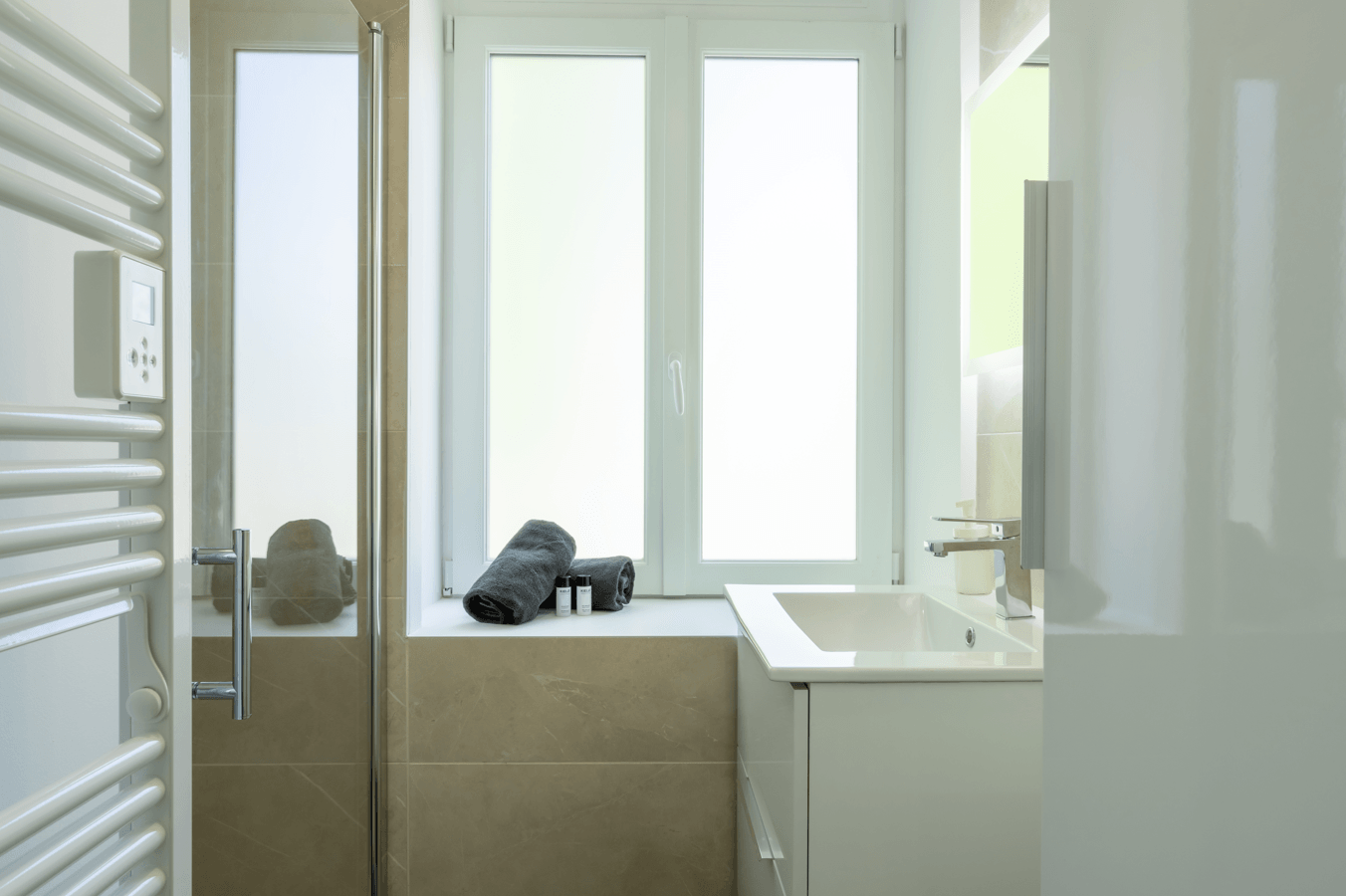 Salle d'eau entièrement refaite avec carrelage marbre beige et miroir rétro-éclairé à Dax