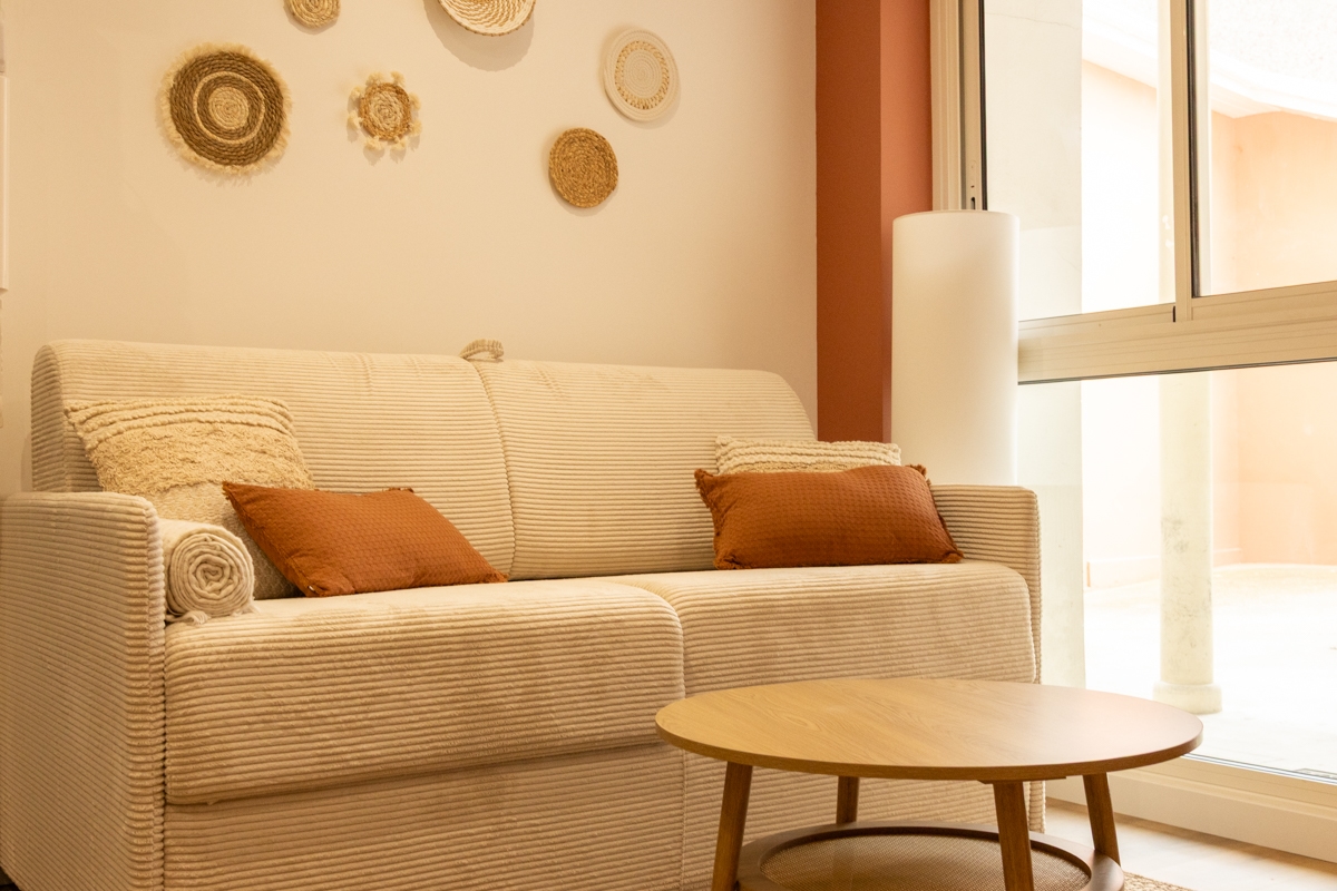 Canapé et espace détente aménagés dans un appartement locatif à Dax